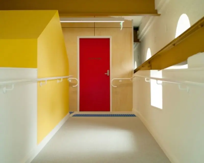 Corridor ramp with red door and white and yellow walls