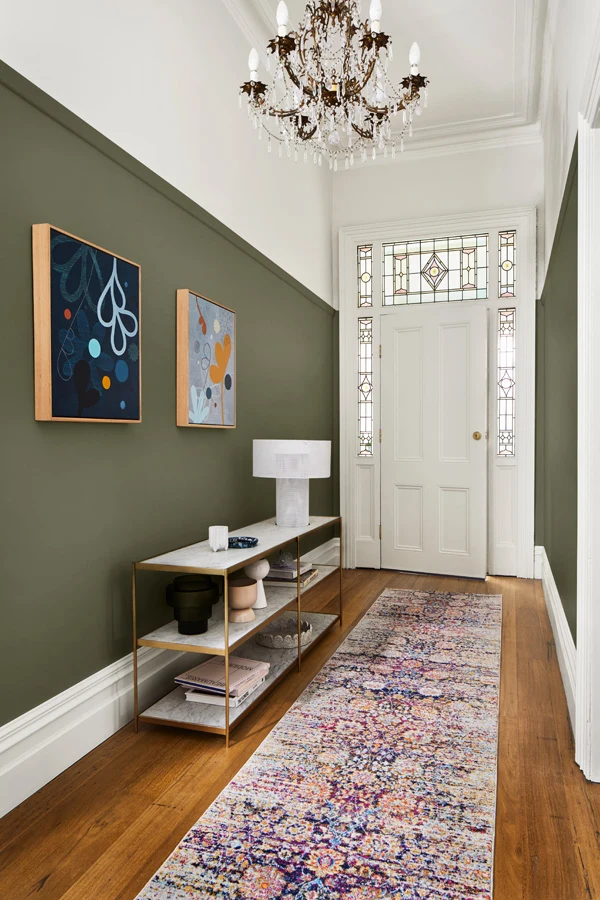Entrance with runner rug and white door with green walls