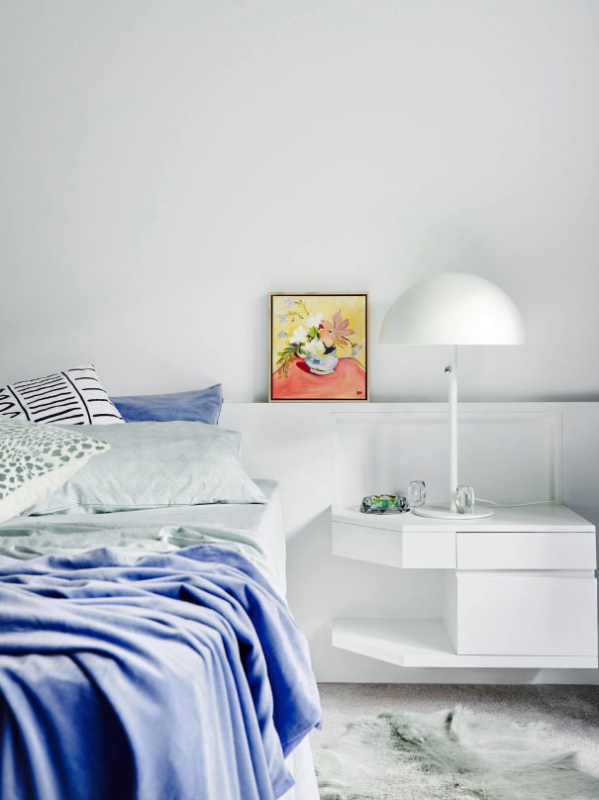 White bedroom with bed and blue sheets