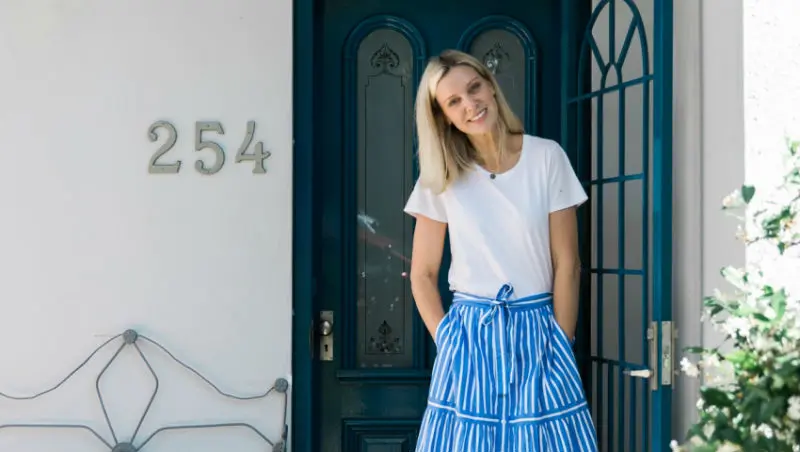 view of woman standing by blue front door 