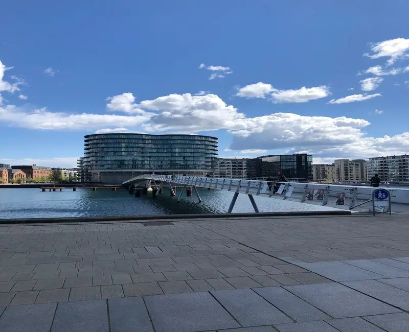 exterior blue building with bridge crossing water.