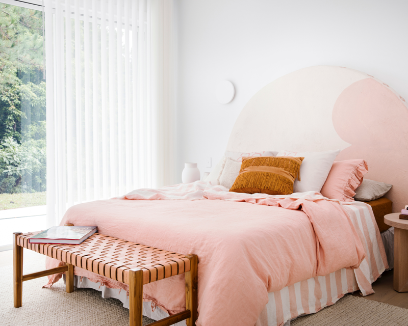 Hinterland Hideaway bedroom in white on white with pink and white bedhead and linen