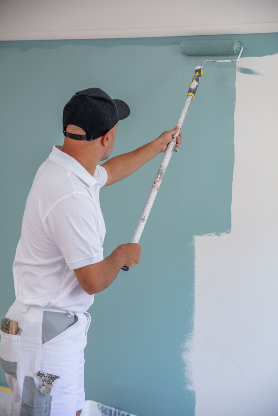 Dulux Accredited painter painting wall with Blue paint. 