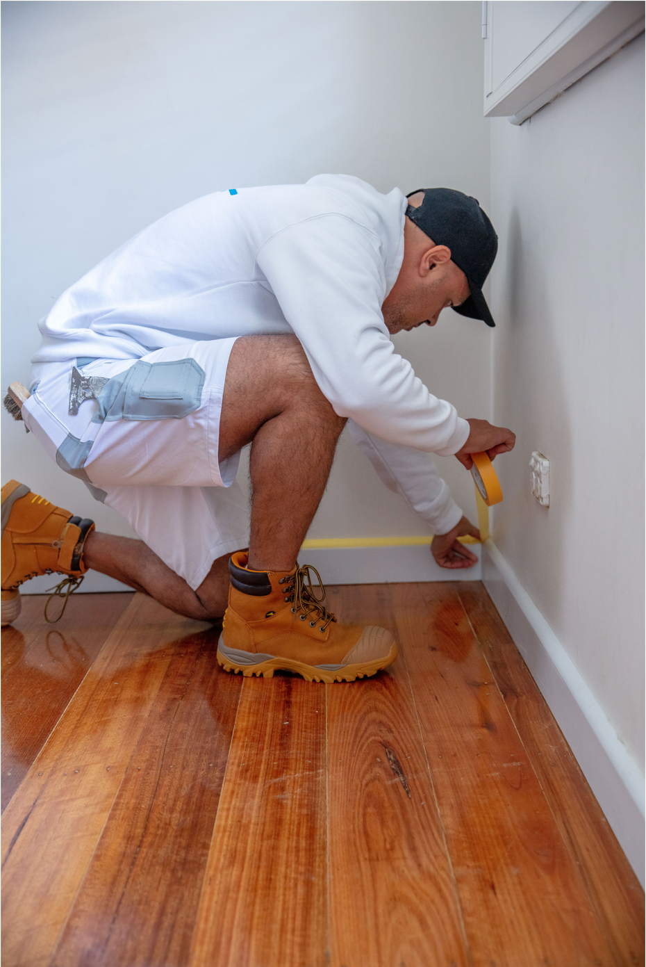 Dulux Accredited painter cutting in to wall in preparation for painting job for a client.