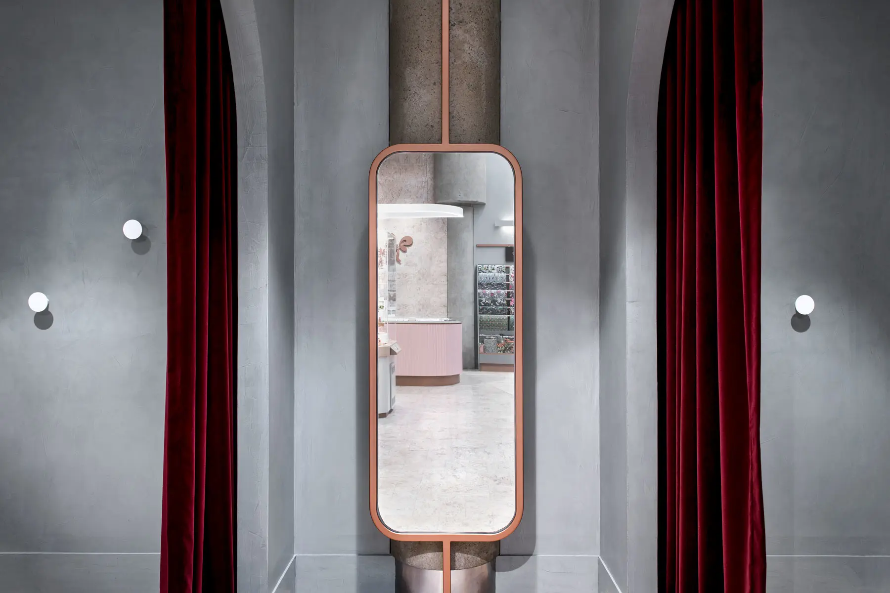 Full-length mirror in grey dressing room with red velvet curtains