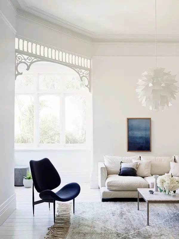 white living room with neutral couch and navy velvet chair