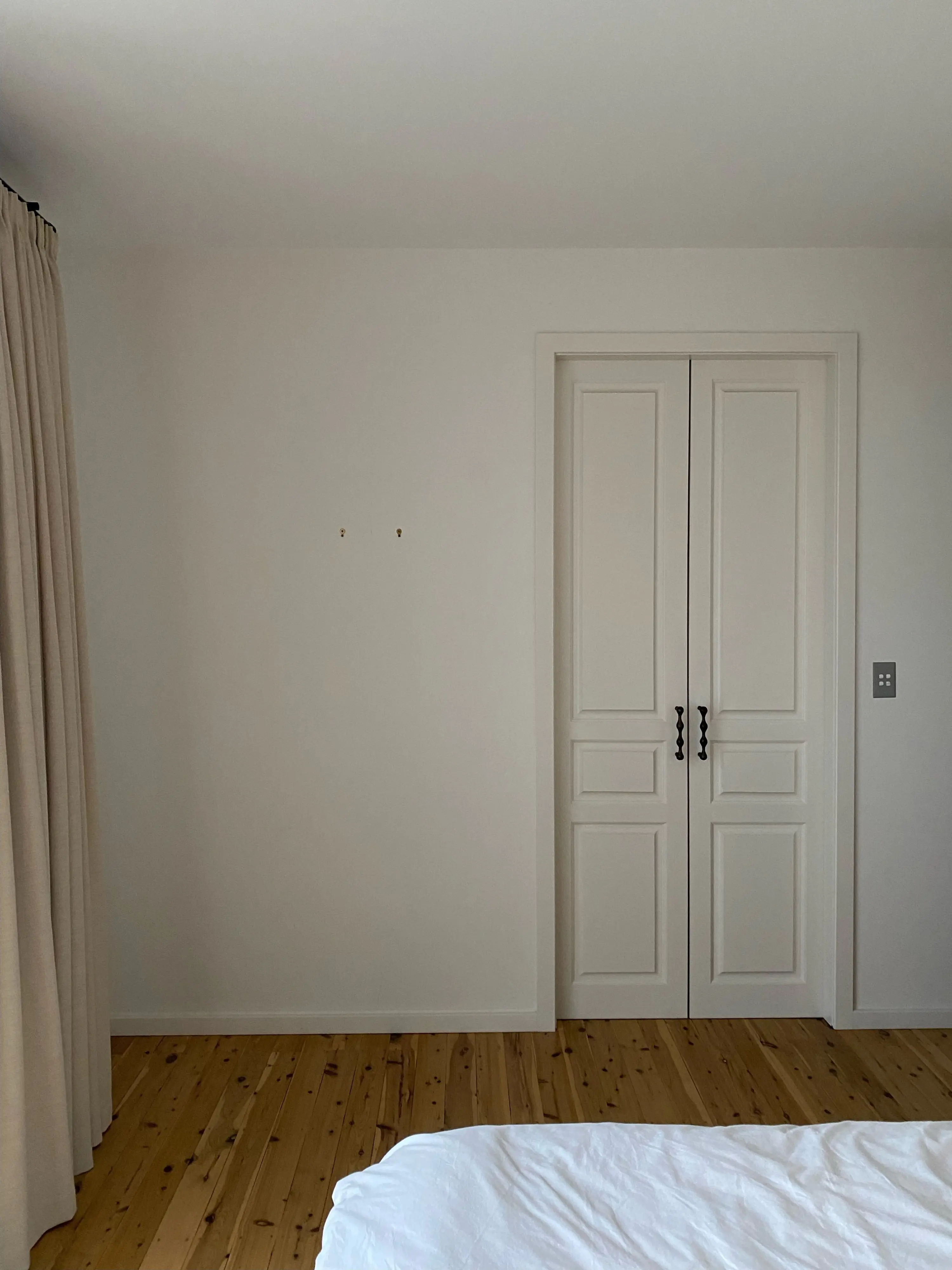 White bedroom with white door before image