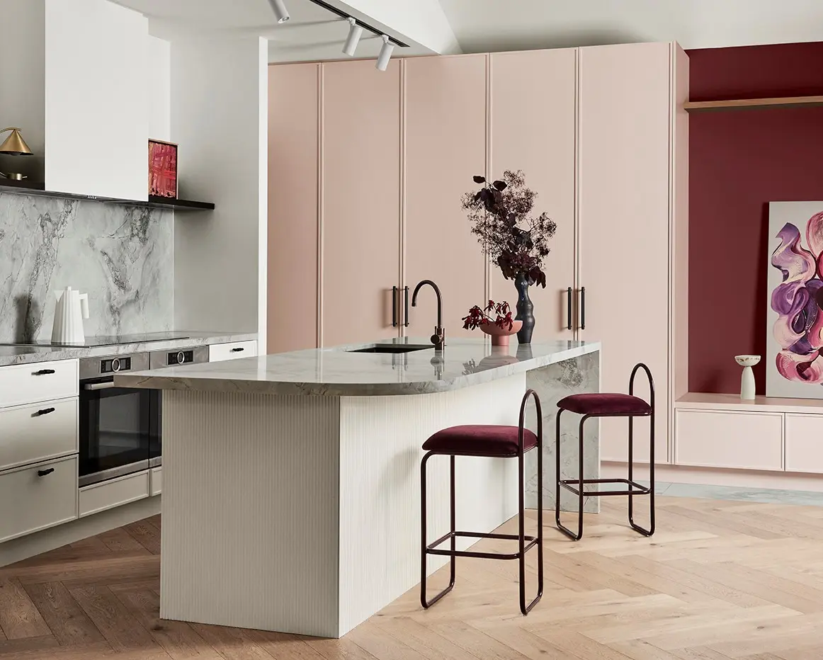 Modern kitchen featuring marble island with pink and red walls