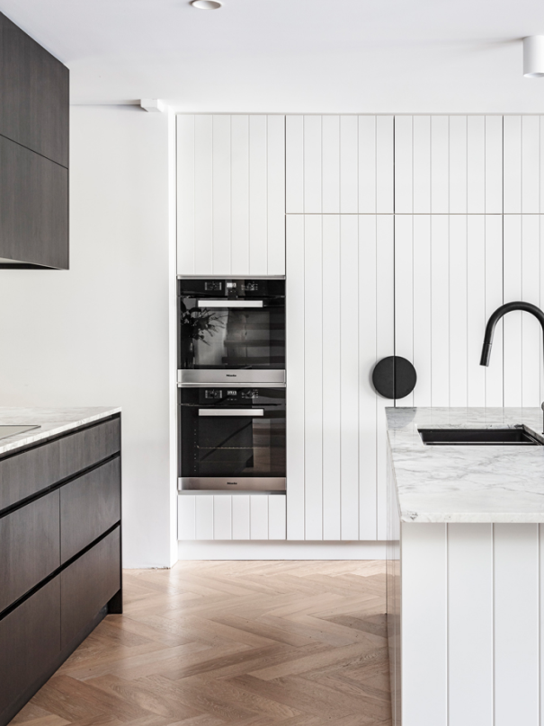 interior white kitchen with marble benchtops and black details.