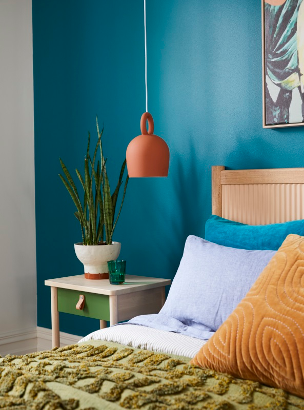 A bed juxtaposed against a blue wall