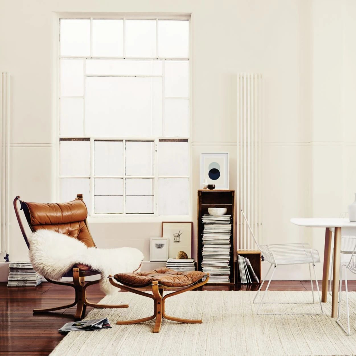 Industrial design living/kitchen area with leather chair, foot stool and storage in background.