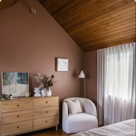 Interior bedroom featuring brown wall and wooden panelling on roof after paint transformation.