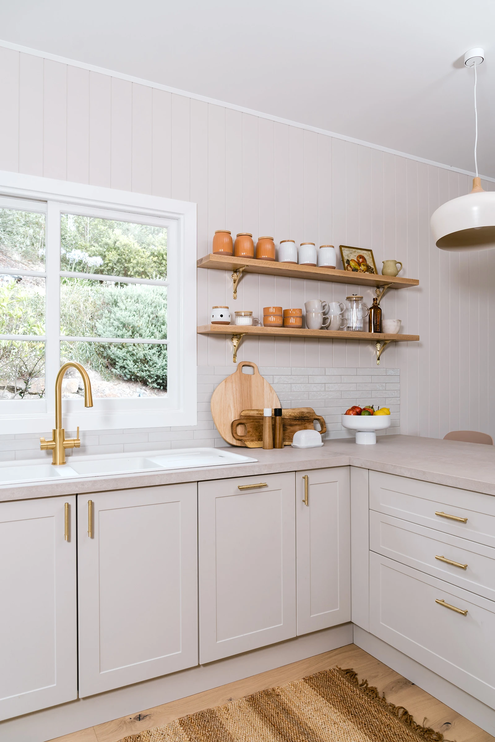 Beige neutral kitchen with floating shelves and gold tapware