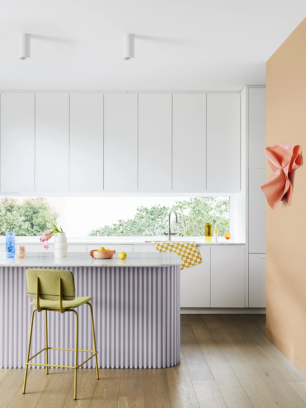Colourful kitchen with lilac island bench and peach feature wall