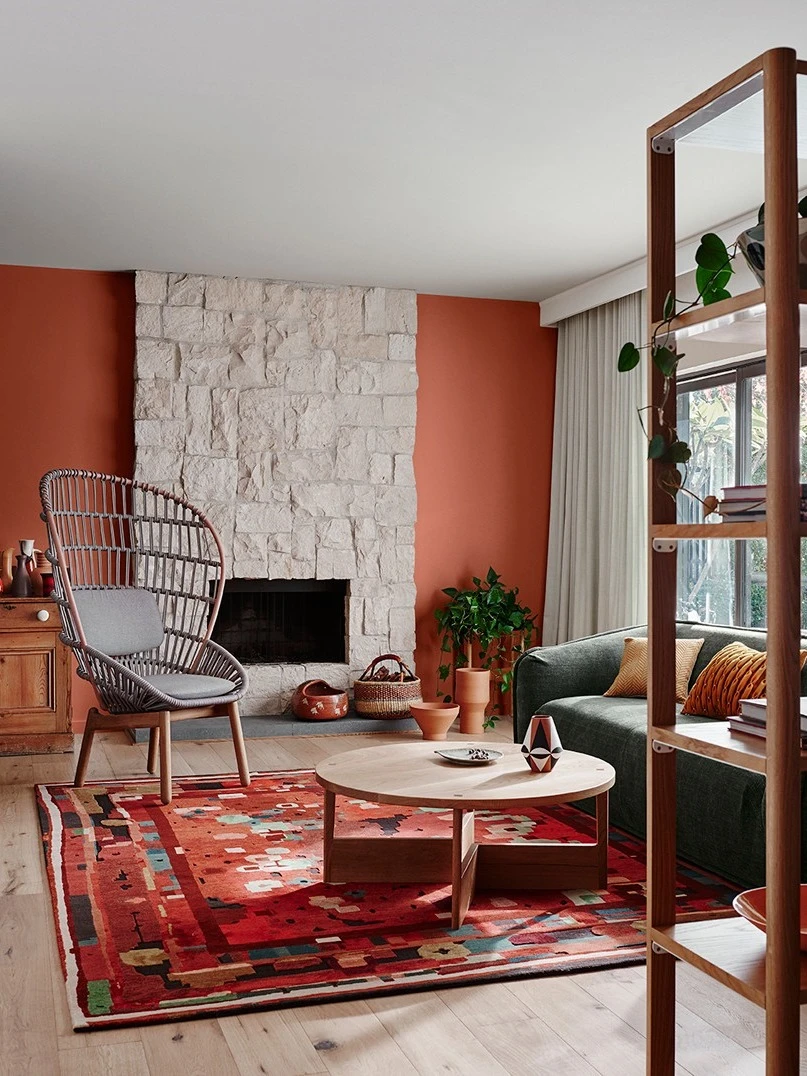 Living room with stone fireplace and terracotta feature wall