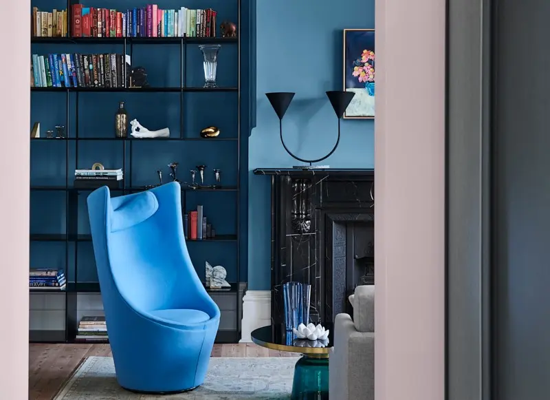 interior lounge with blue chair and bookshelf.