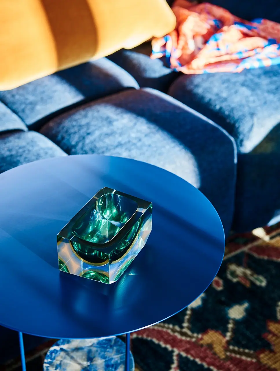 interior blue coffee table with green glass sculpture.