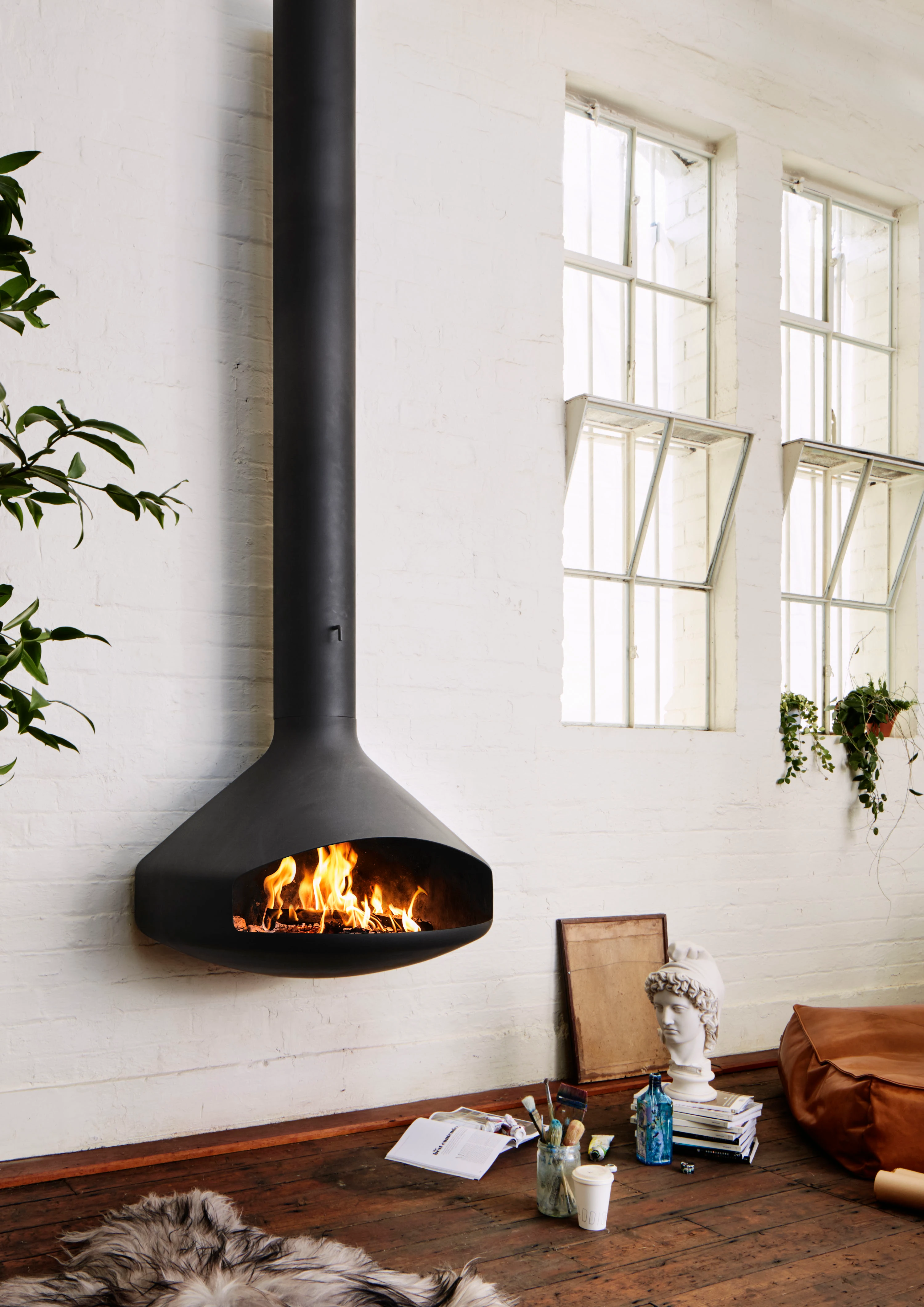 interior floating circular fireplace on white brick wall.