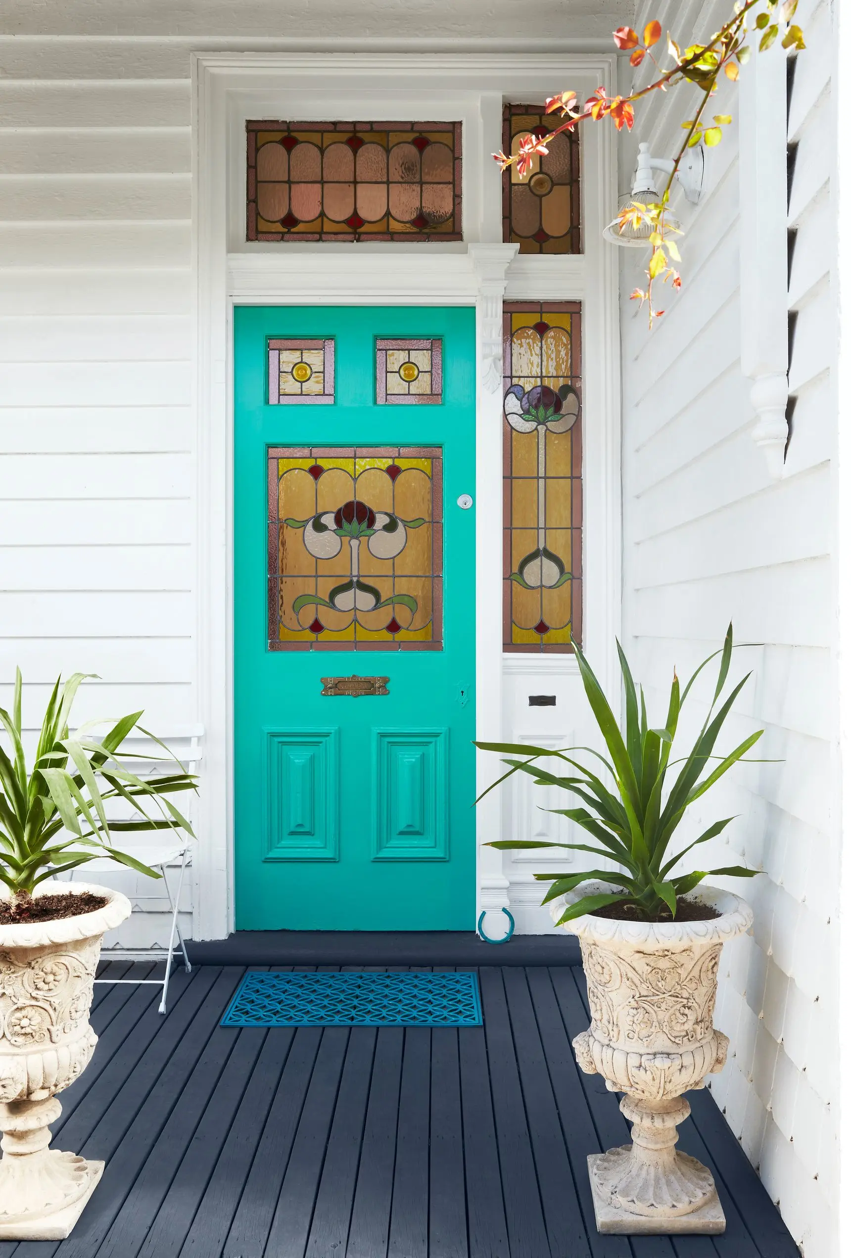 White weatherboard, teal front door, stained glass side windows and door insets