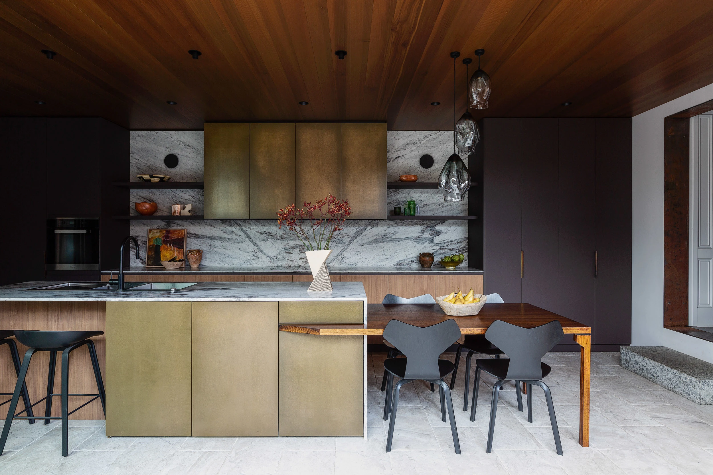 Kitchen with timber ceiling, gold cabinets and marble splashback