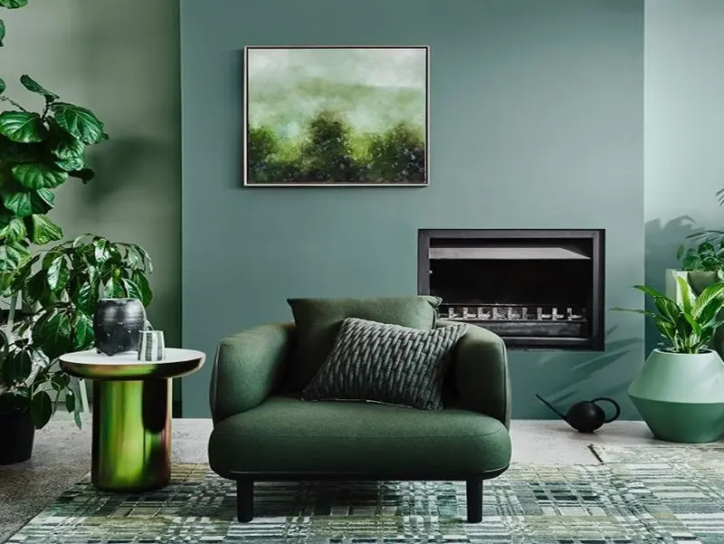interior lounge room, green chair and fireplace.