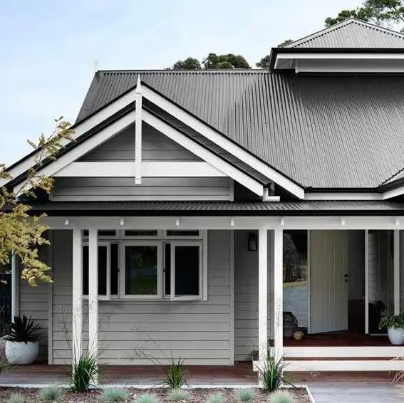 Grey weatherboard Victorian house with white trim and dark grey iron roof