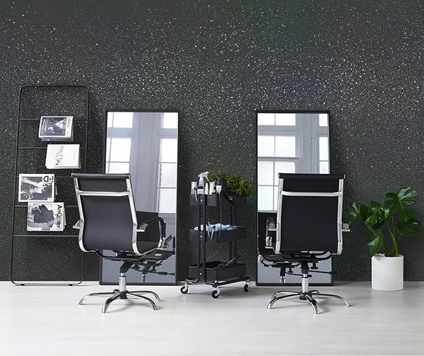 Hairdressing salon with full-length mirrors against a black and silver glitter wall.