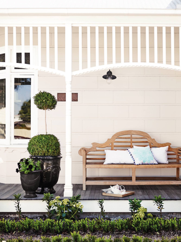 exterior white verandah with wooden bench.