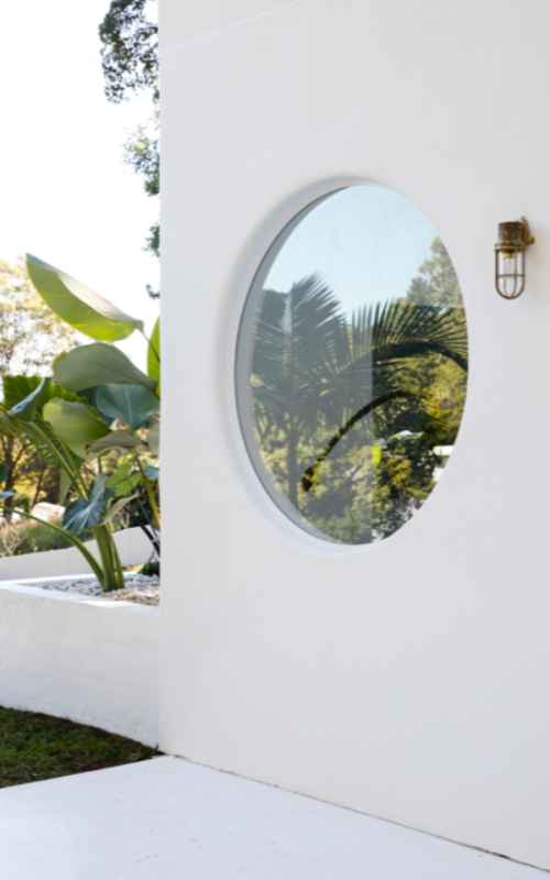 Round window feature at Hinterland Hideaway project in Dulux White on White by Three Birds Renovations.