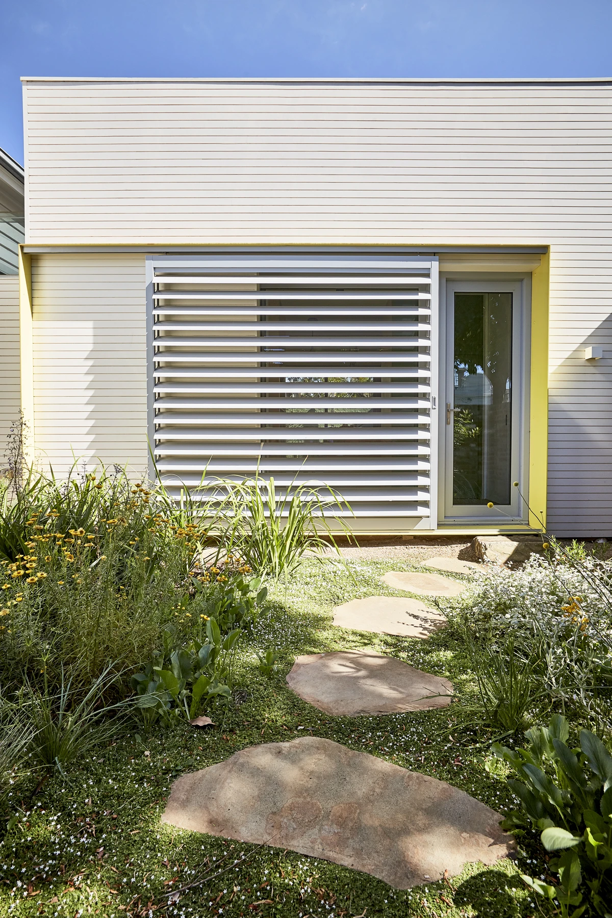 Exterior white modern house with aluminum louvres and yellow trim
