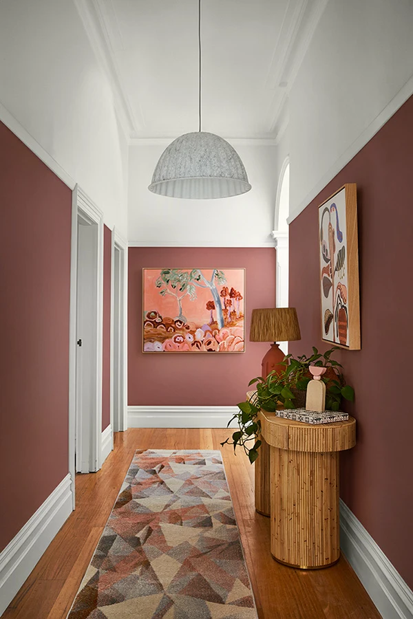 interior pink and white hallway with painting. 