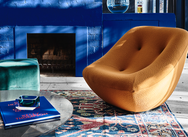 interior brown lounge chair with vivid blue fireplace and oriental rug.