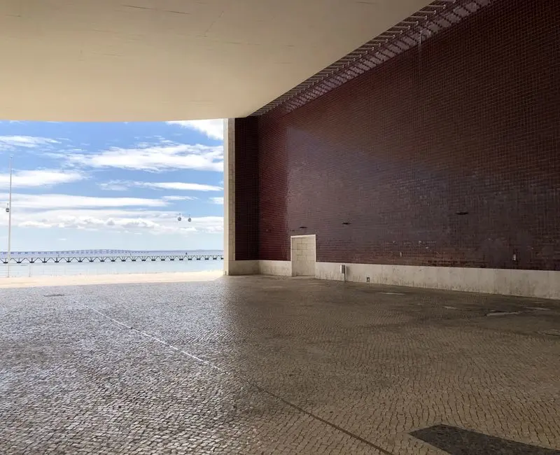 exterior beige covered pathed area, with brown wall.