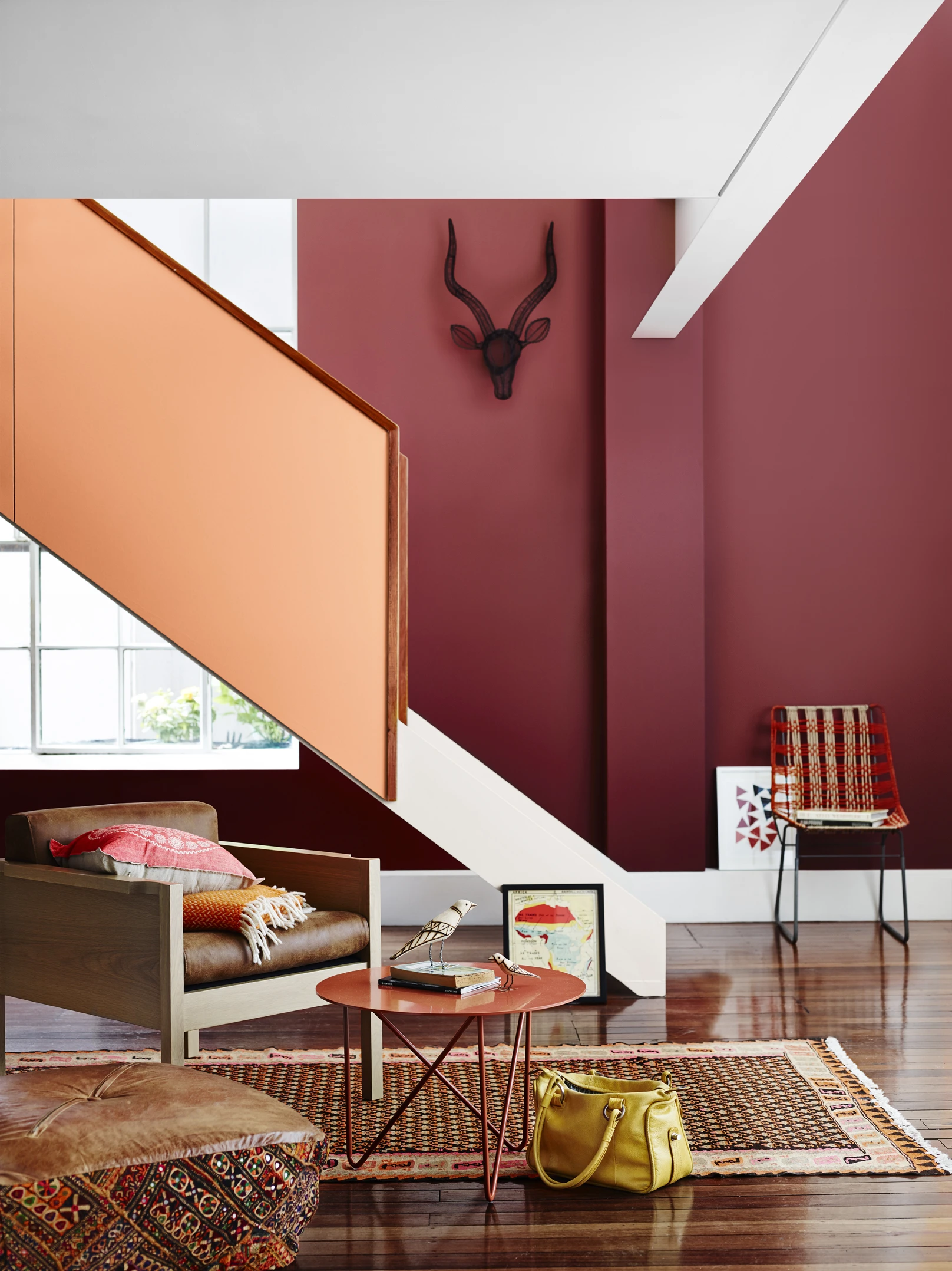 Light orange staircase in living room with deep red walls