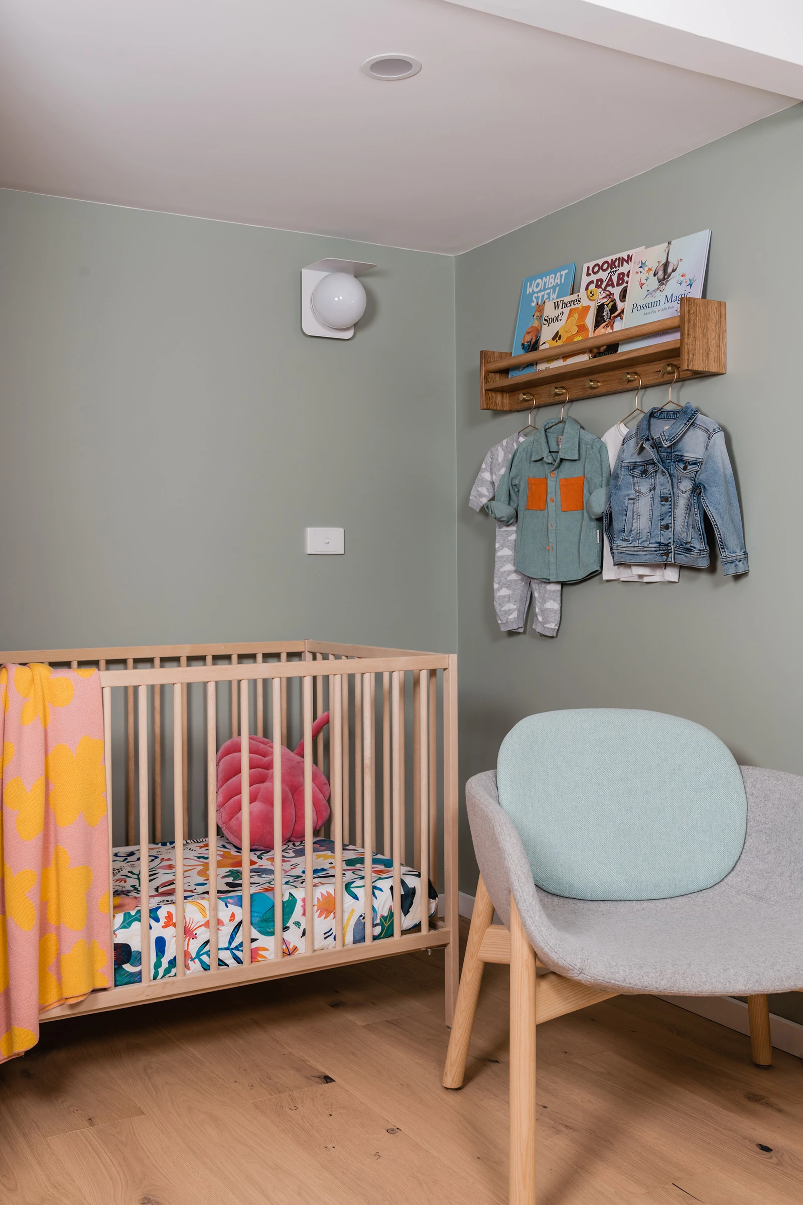 Nursery with timber cot and green walls