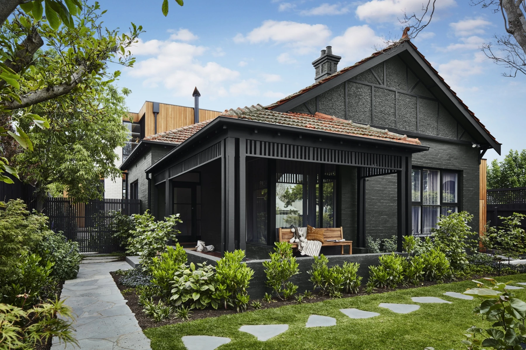 Popular exterior outside schemes, black house and roof with orange red tiled roof, manicured garden with stone pathway.
Colours: Domino (trim) and Teahouse (exterior)
