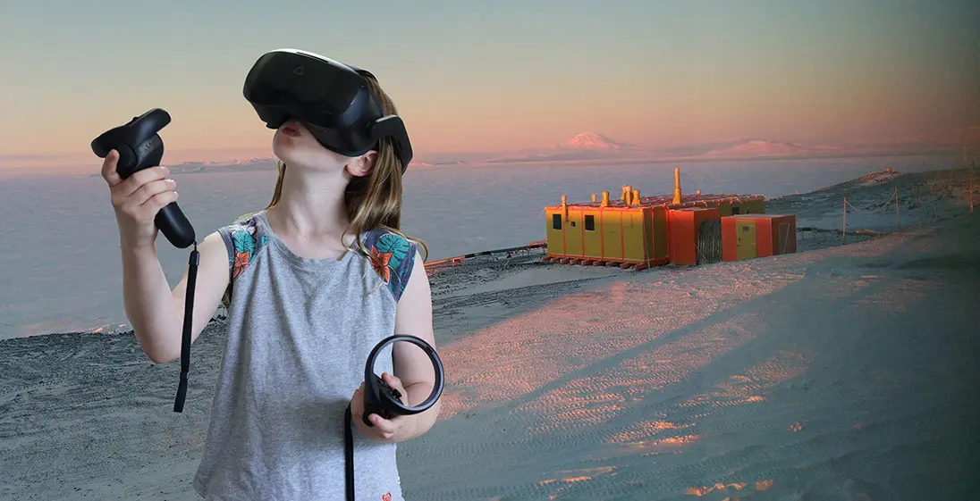 A child using a VR model to look at Sir Edmund Hillary's Hut in Antarctica which can be seen behind her