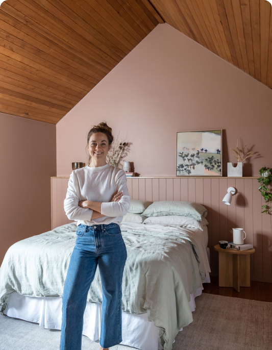 Woman standing in brown bedroom.