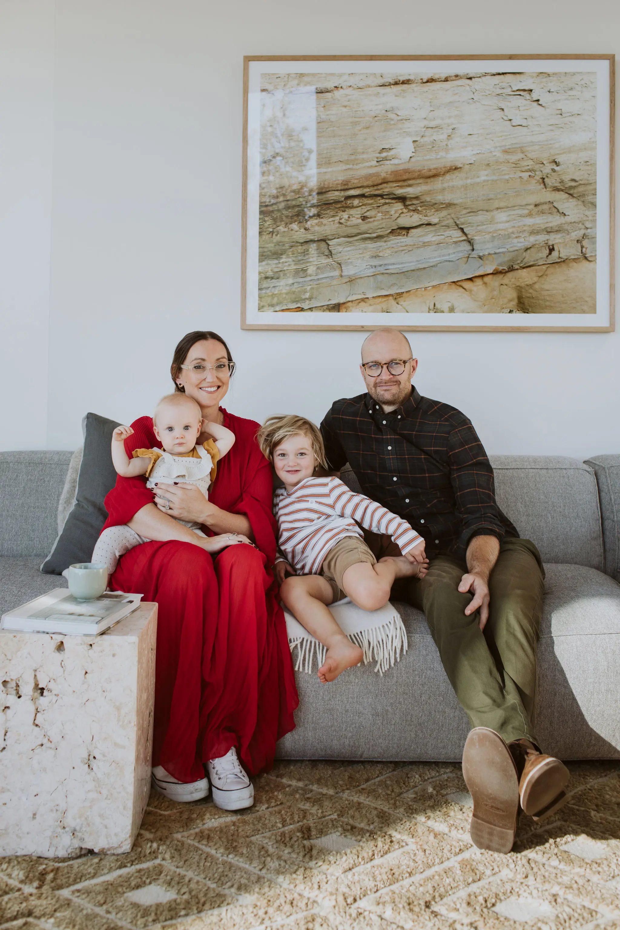 Alex and Corbans' family sitting on a couch, among their design