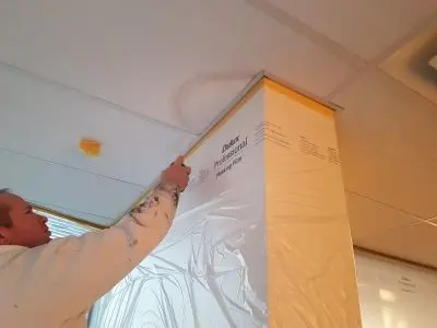 Painter spraying Acousticoat on a ceiling