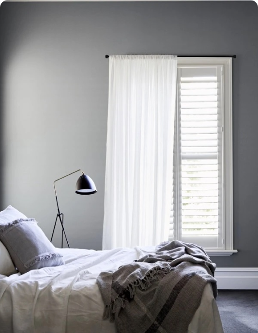 Bedroom with grey walls and white windows and louvres