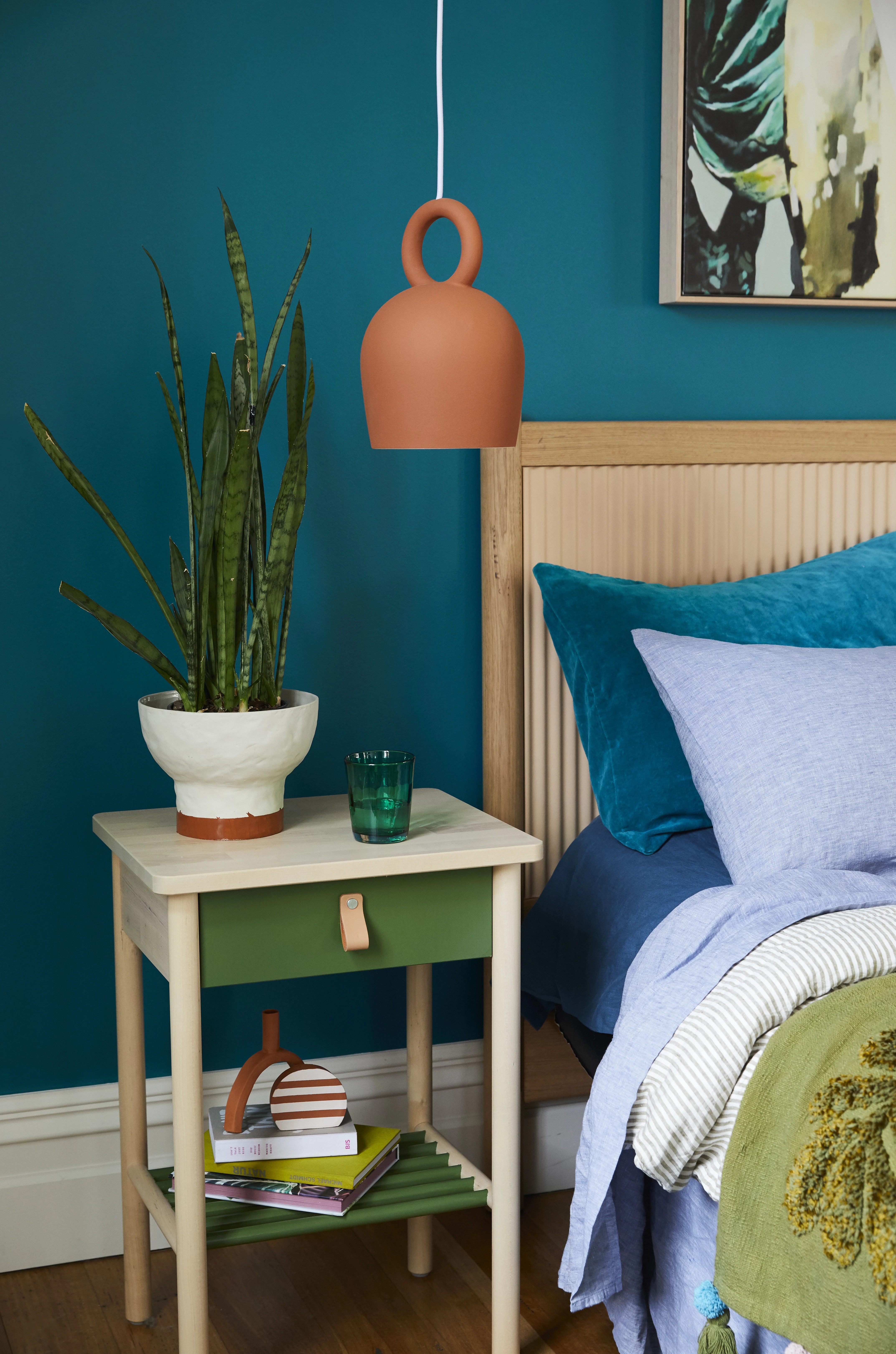 Bedroom with blue green wall and hanging pendant light