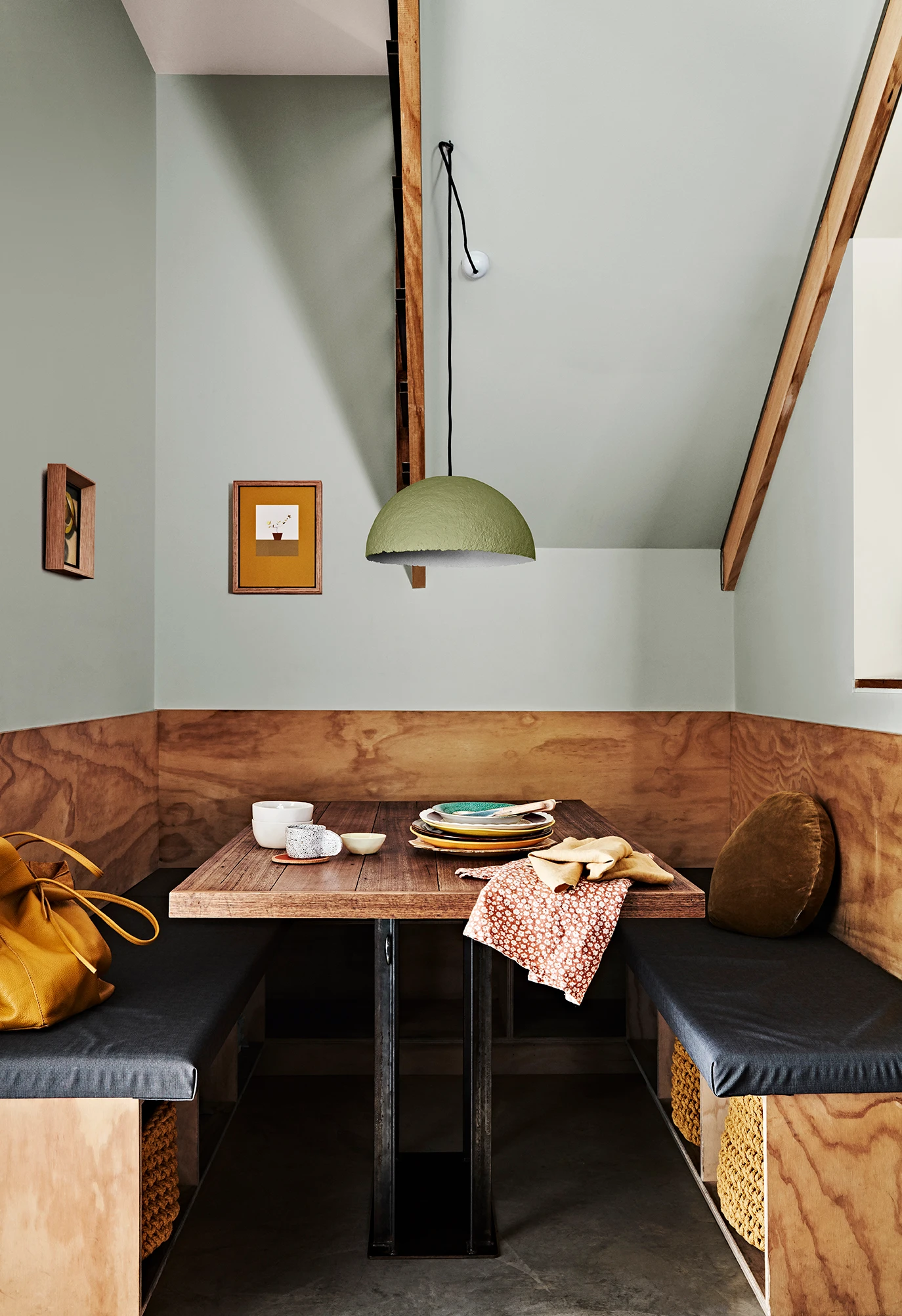 Green dining room alcove with black bench seats.