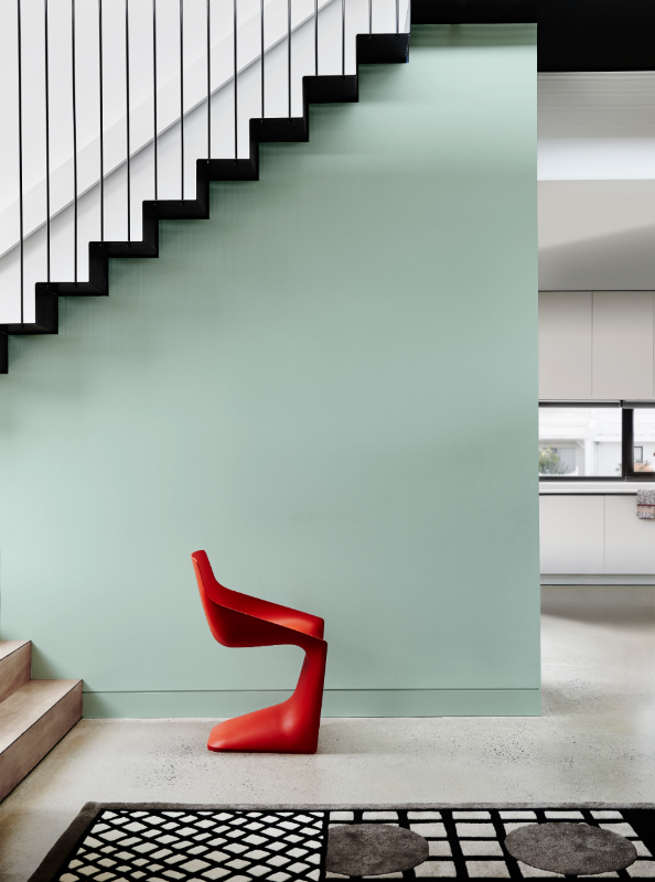 Dulux Wash&Wear® in Carnelian on staircase wall, terrazzo floors and a modern red chair.
