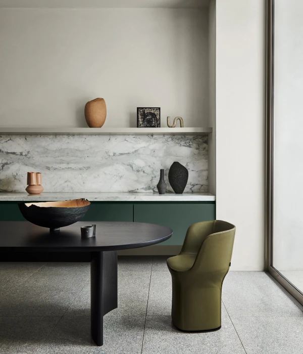 Minimalist dining room with green cabinetry and black table