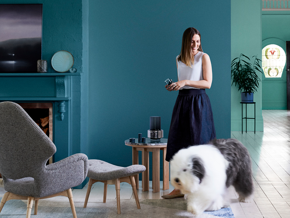Woman and dog in teal living area.
