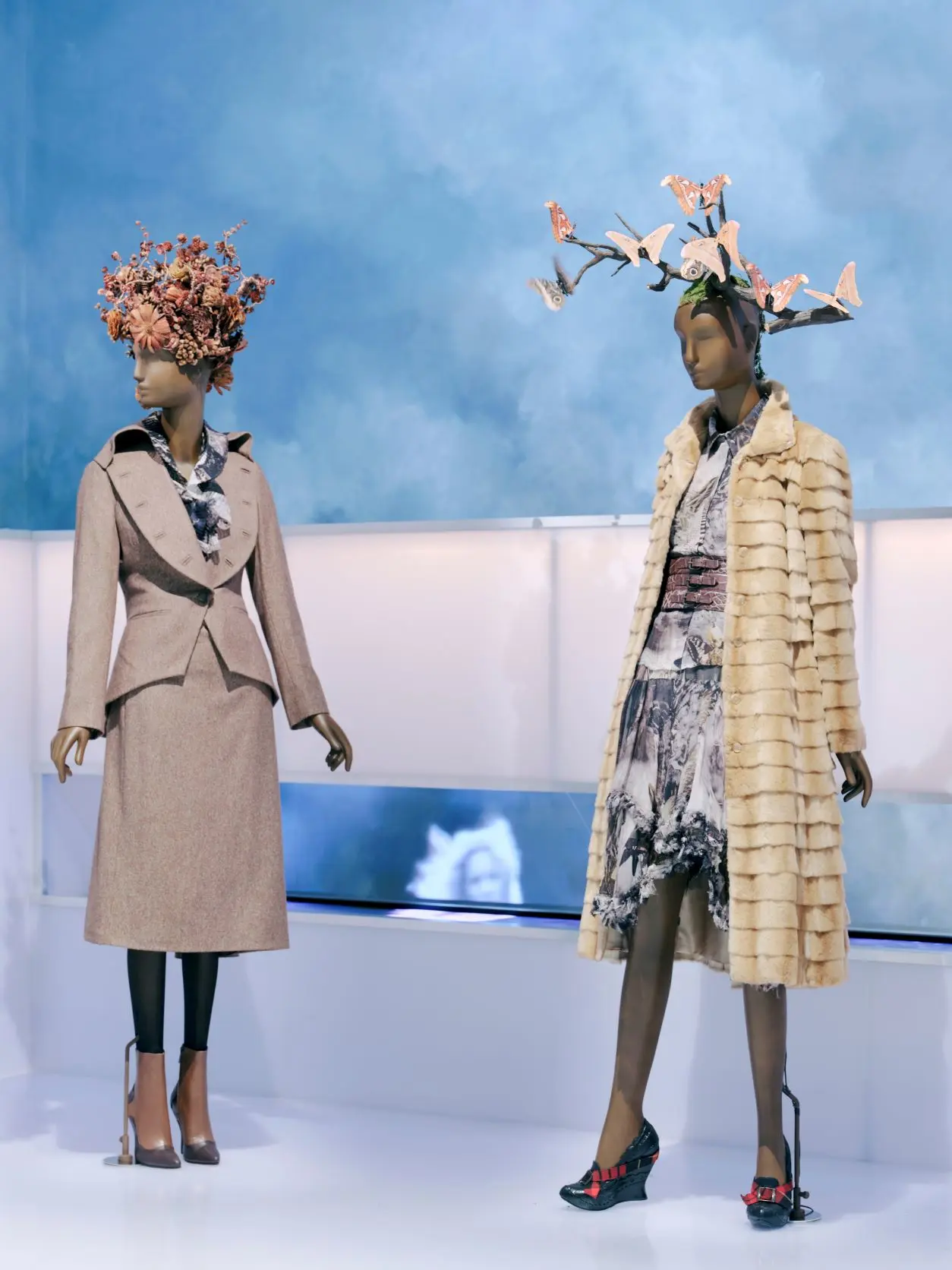 NGV Alexander McQueen mannequins with headpieces against cloudy backdrop