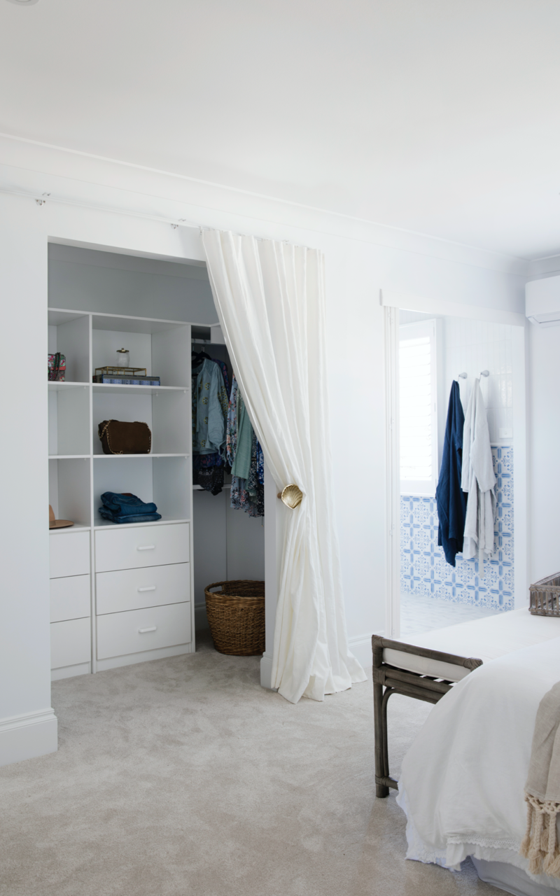 Walk-in wardrobe with curtain cover. Colour Me Hamptons project by Three Birds Renovations.
