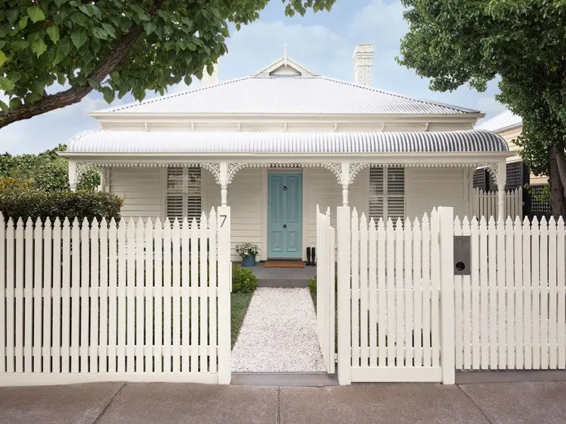 White fence and white house with blue door