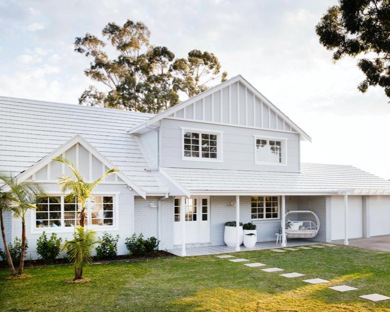 White and grey double-storey house in Hamptons style